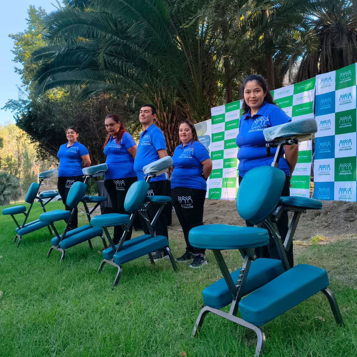 Equipo del Programa de Bienestar Inclusivo junto a sillas de masoterapia