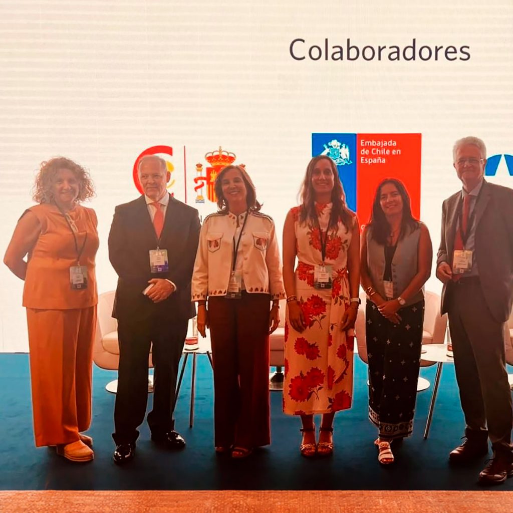 Seis representantes posan en un escenario frente a los logos de la Embajada de Chile en España y otras entidades colaboradoras.